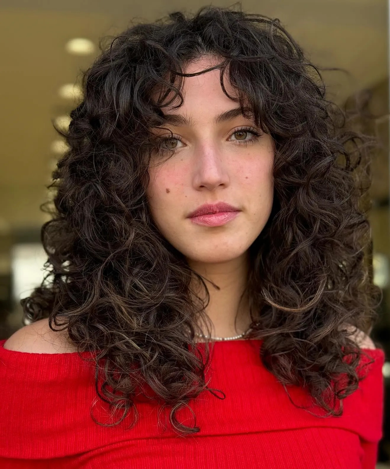 14. Effortless Curly Shag with Layered Bangs